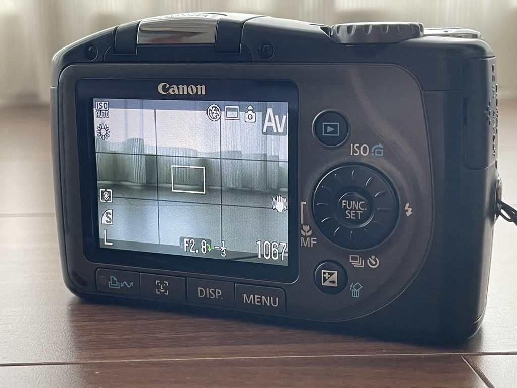 PowerShot SX100 ISの背面液晶モニターと操作ボタン。電源を入れ、実際の風景を映し出している状態。