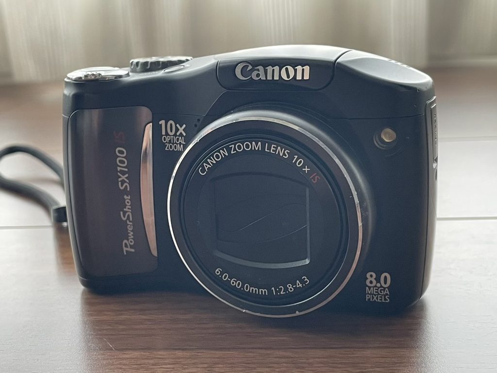 Canon PowerShot SX100 IS（ブラック）の正面外観。丸みを帯びた愛嬌のあるボディデザイン。